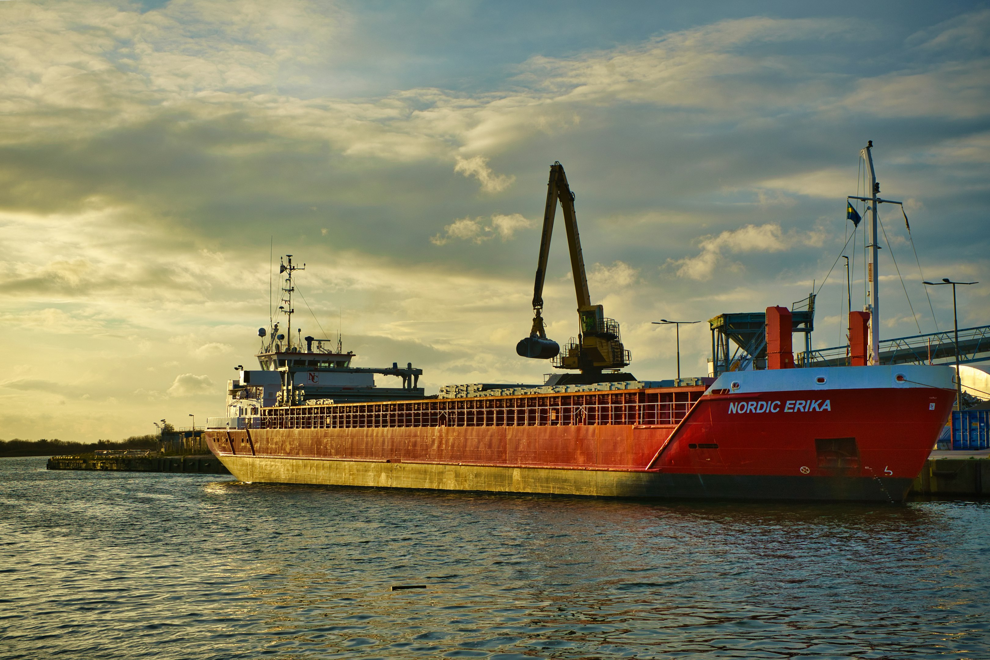 un gran barco rojo flotando en la superficie de un cuerpo de agua