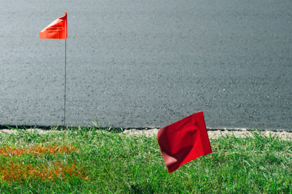 Red utility warning flags in the grass

