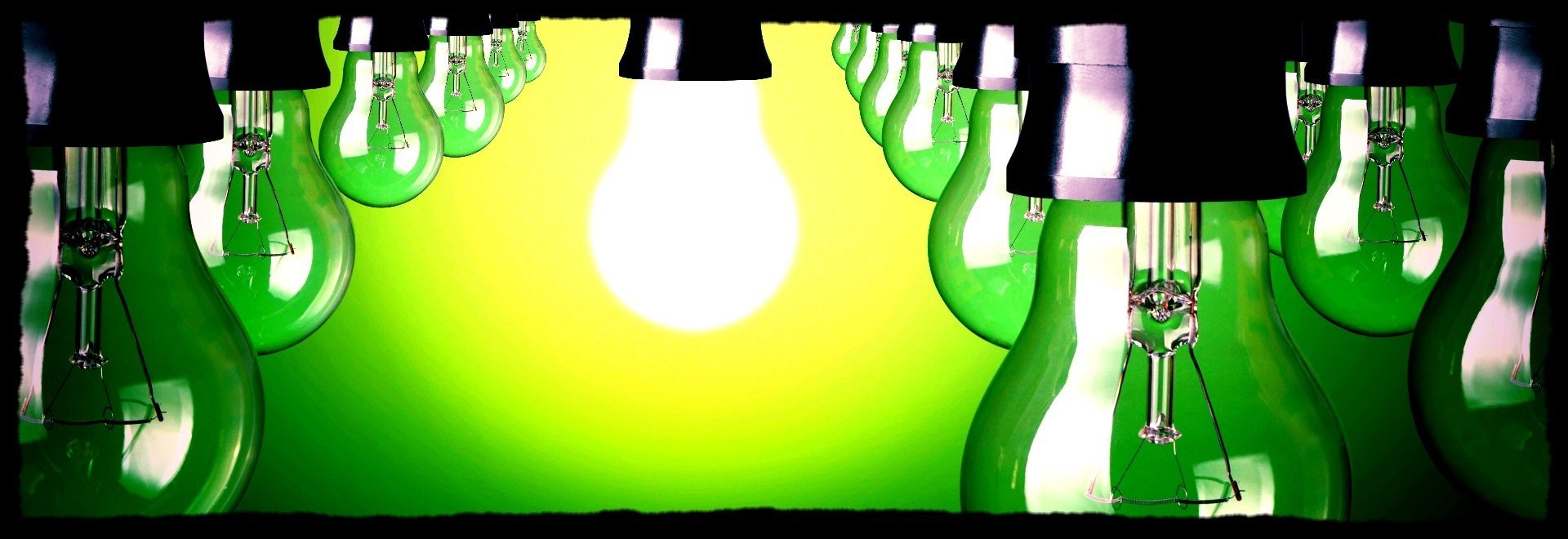 Bombillas verdes con luz resplandeciente sobre fondo amarillo.