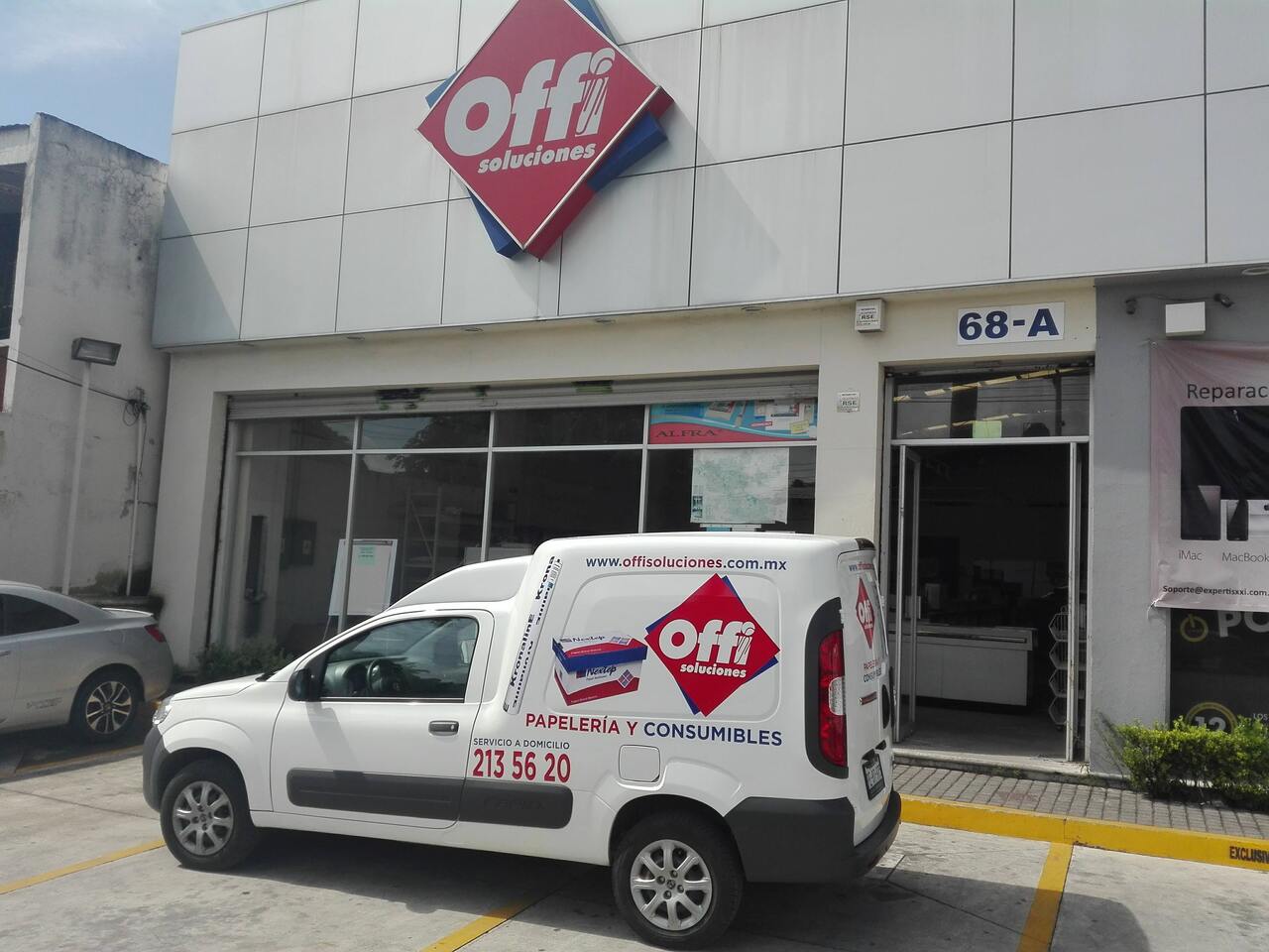 Fachada de la tienda Offi Soluciones con camioneta de papelería estacionada al frente, ubicada en el número 68-A.