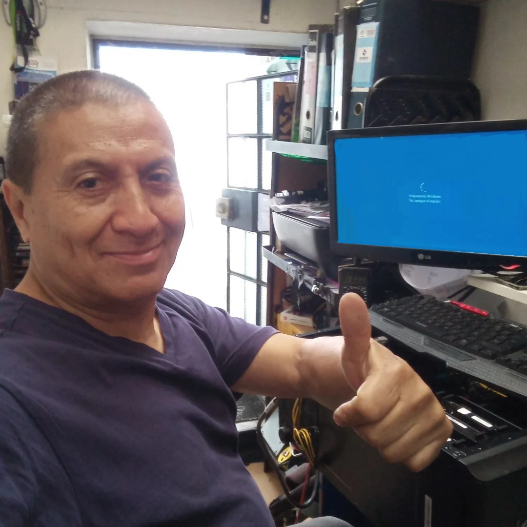 Ordenador en escritorio moderno con pantalla mostrando gráficos tecnológicos y plantas decorativas alrededor, en oficina luminosa.