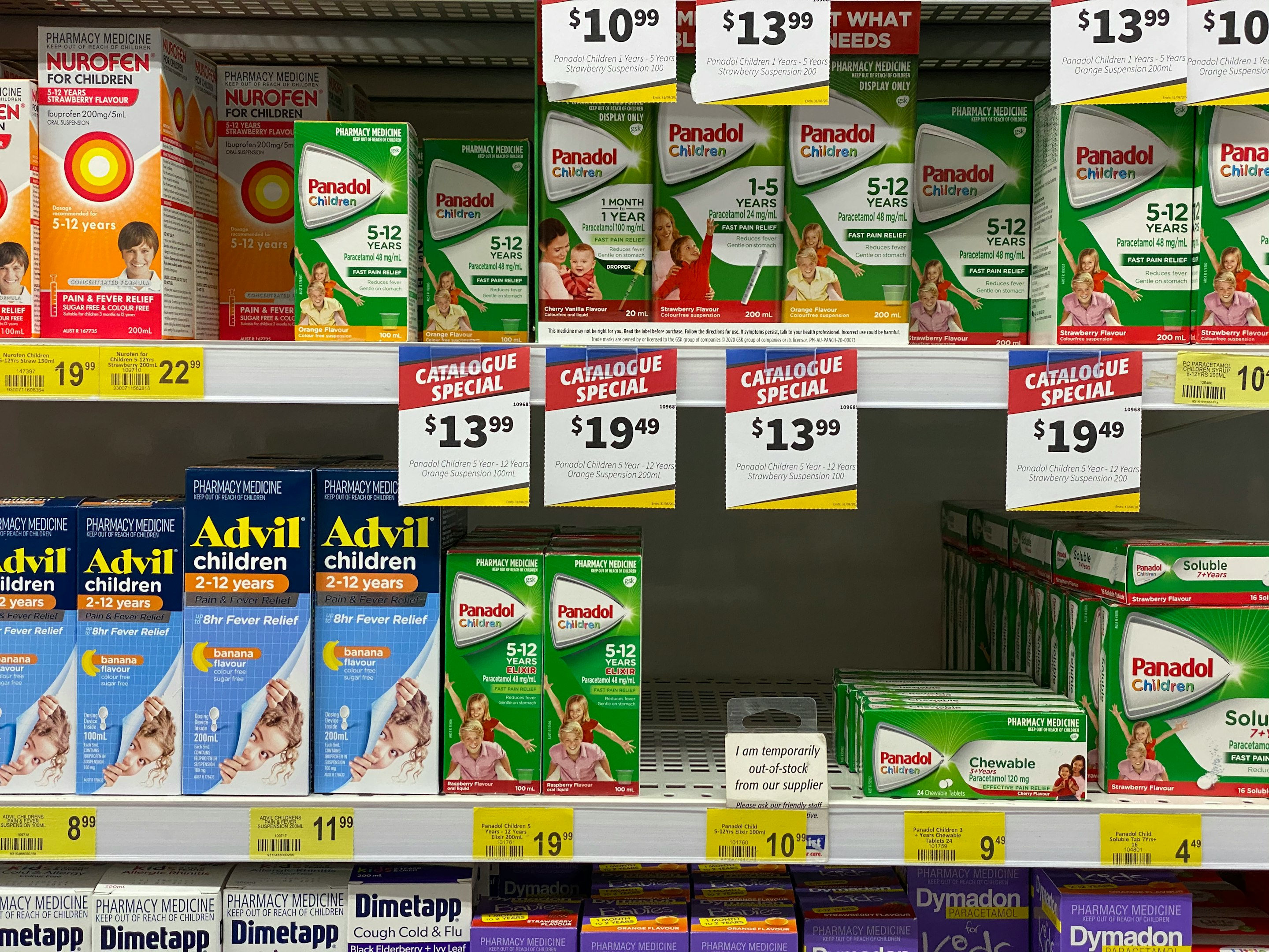 Interior de una farmacia moderna con estantes llenos de medicamentos y mostrador con computadora.