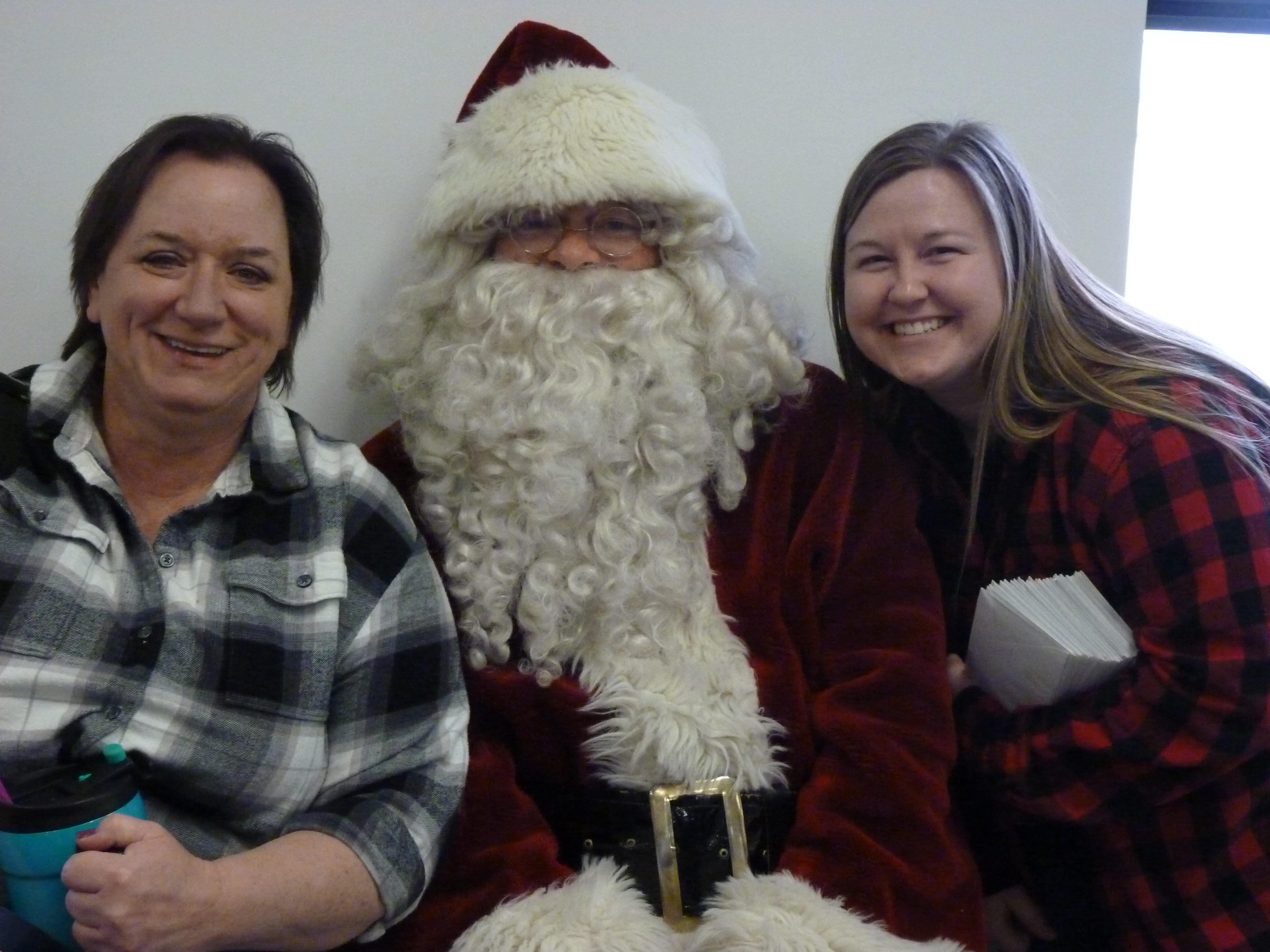 Jennifer, a supervisor and Sandy, bookkeeper smiling with Santa
