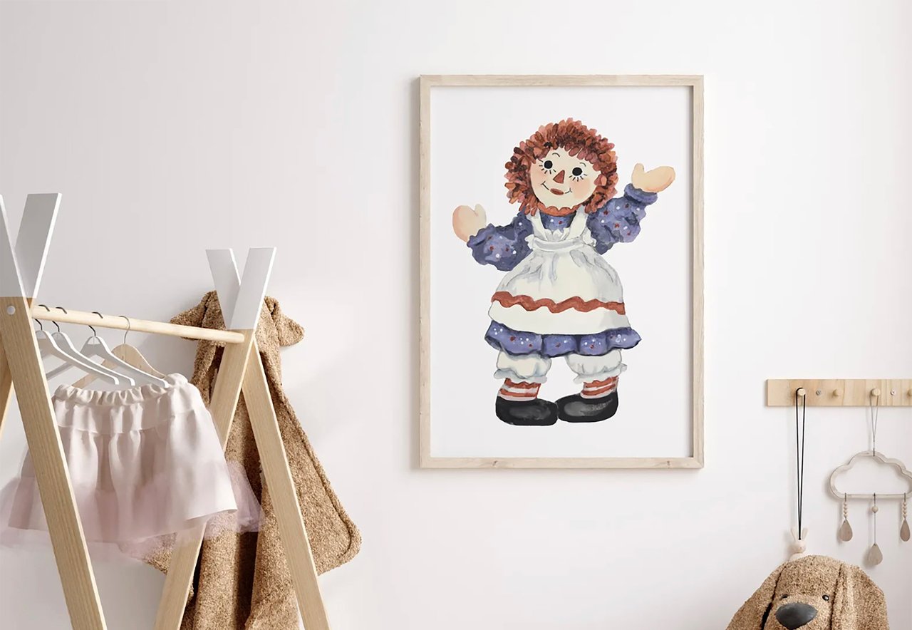 Kids' room interior with framed picture of a doll on the wall, clothes rack with a skirt and teddy bear, wooden decor items.
