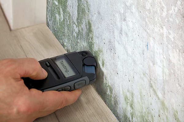 Using a moisture meter to check the moisture content of building material