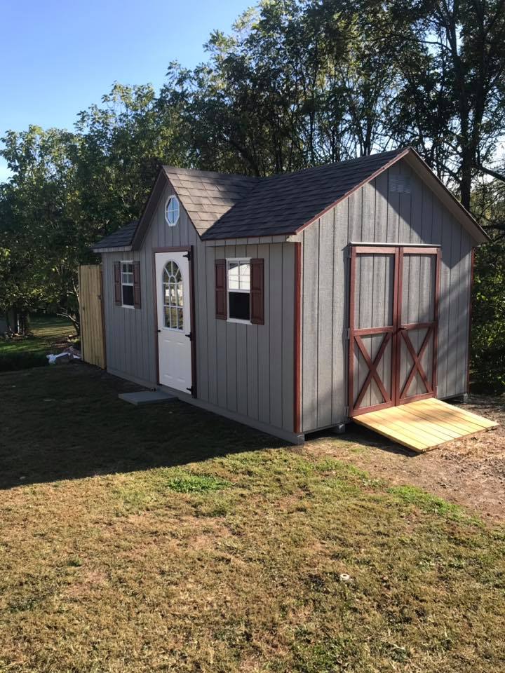 10 x 16 Cape Cod Dormer  
                                                      
Featuring light gray wood siding, red trim, and weatherwood colored 30 architectural shingles. Equipped with red colored raised panel shutters, Standard features include gable vents, Roof Dormer 12/12 pitch, 1- 11 lite steel door, 5’ wide double doors, 14” octagonal window, 2- 18”x27” slider windows with screens.
                                                       Featured options treated ramp 