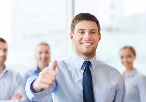 Smiling Employee Showing Thumbs Up in Office