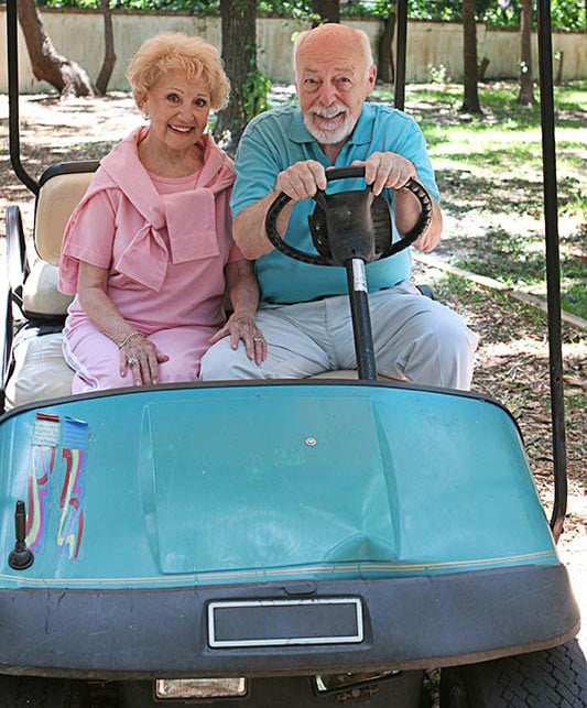 A senior couple in a golf cart A senior couple in a golf cart