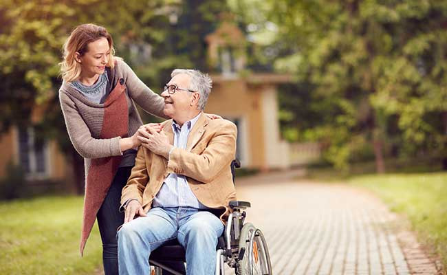 Senior Man In Wheelchair With Caregiver Daughter