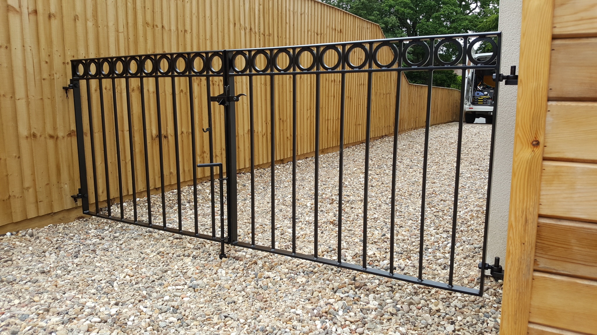 Simple, modern double drive gates with decorative rings & satin black powder coating.