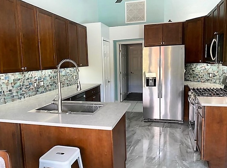 Stunning kitchen featuring a fun
backsplash and gorgeous tile flooring. 
