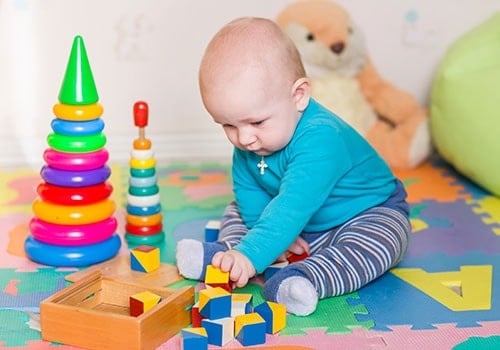 Cute Little Baby Playing With Colorful Toys