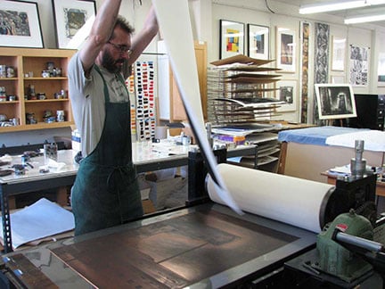 Printer David Avery pulling a print of Jenny Robinson's Third Street Factory