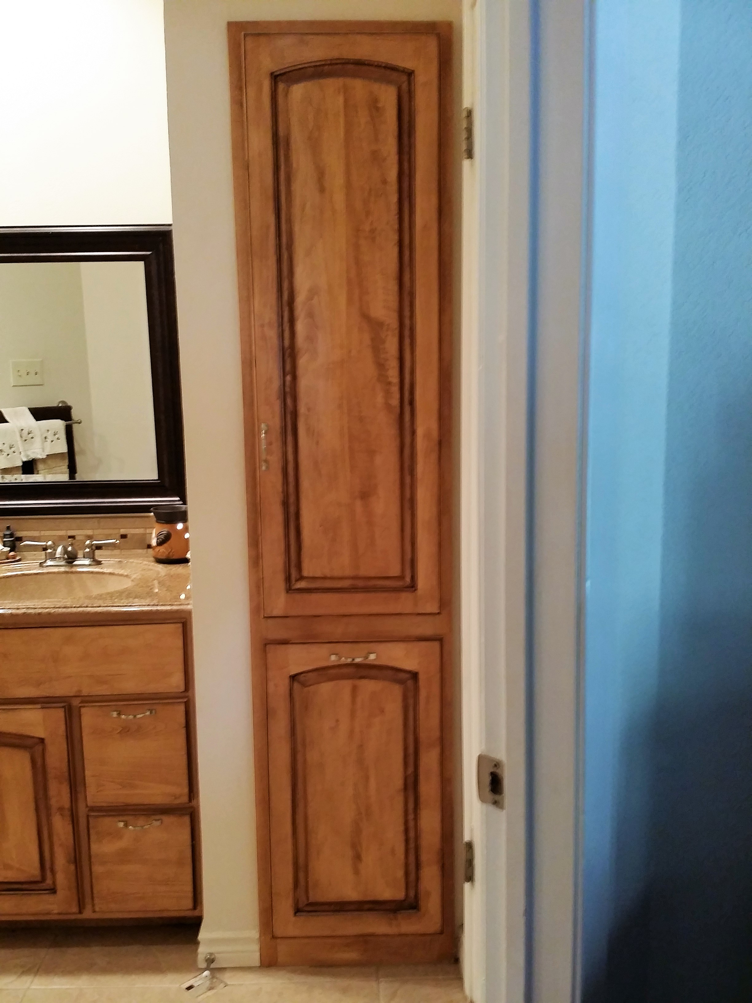 Maple Wood with early American
 stain and walnut glaze cabinet features
 a linen closet and a slide out hamper with
Arched Raised Panel Doors.