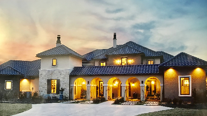 A large home with porch lights on