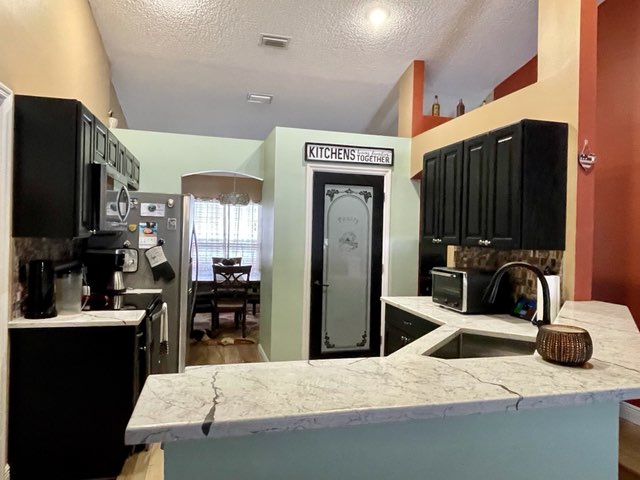 Bright kitchen featuring dark rich cabinetry and quartz countertops.