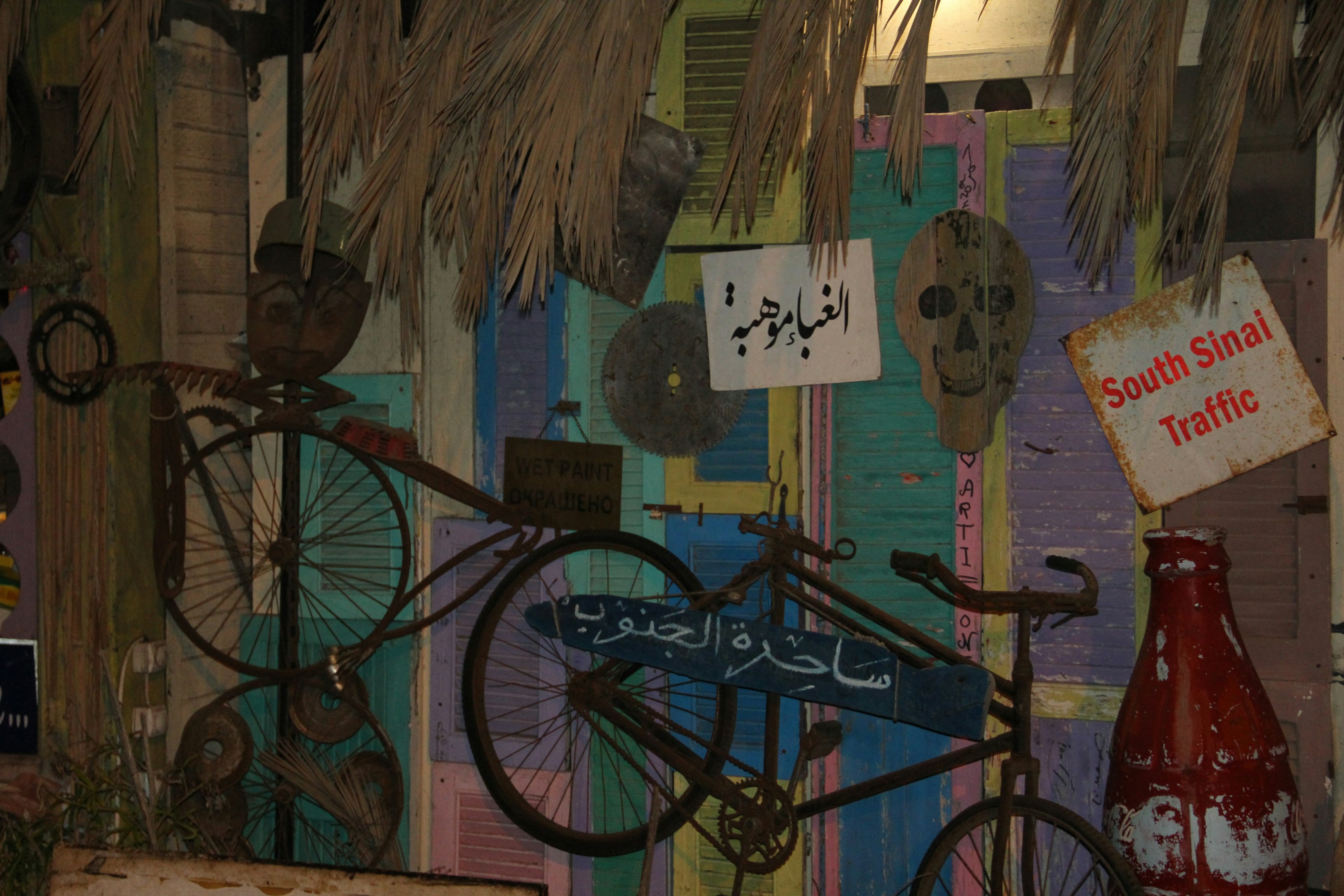 a bike parked next to a wall covered in signs