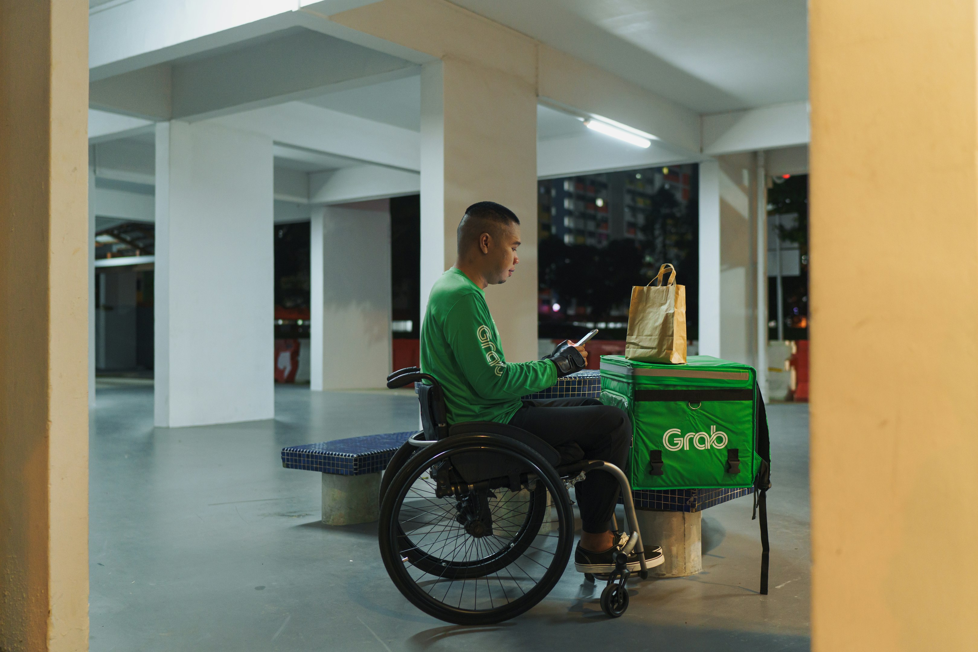 un hombre en una camisa verde sentado en una silla de ruedas