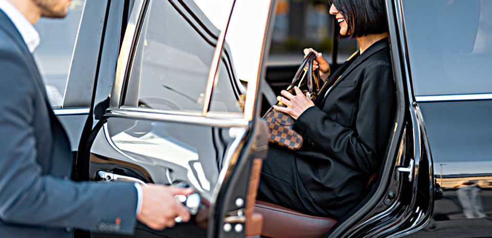 Professional couple inside car, symbolizing corporate travel service