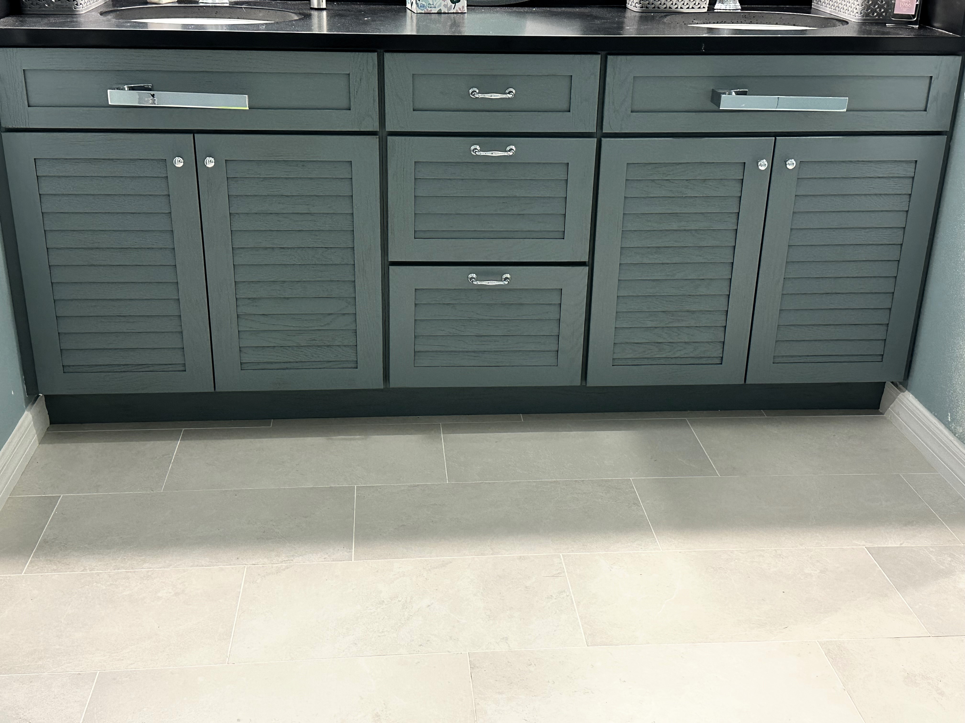 This semi-custom oak door style painted Islander with dry brush featuring Matte Black Pool Cambria quartz countertop gives this vanity a true coastal vibe.  