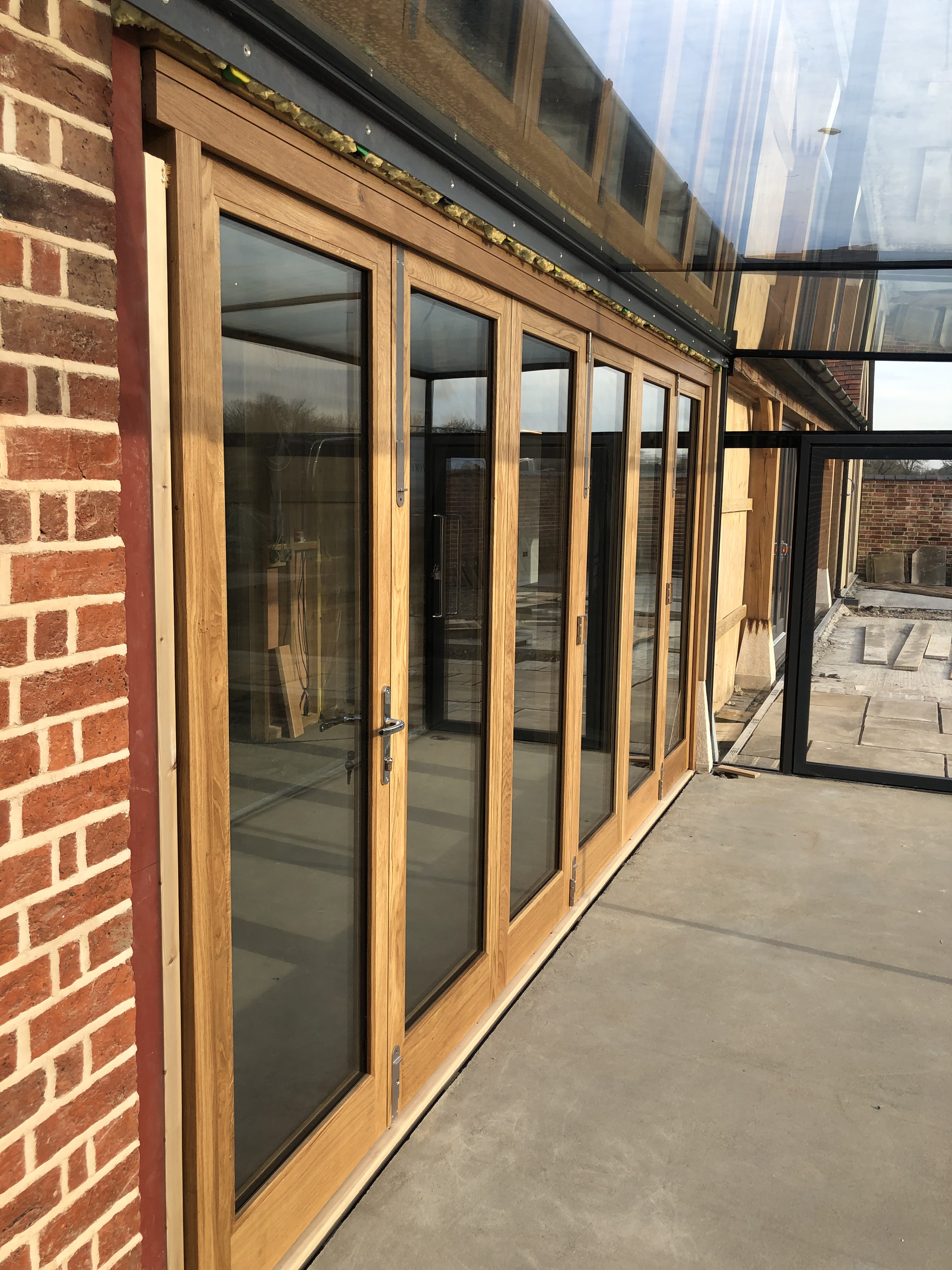 man in black t-shirt and gray pants standing near white wall