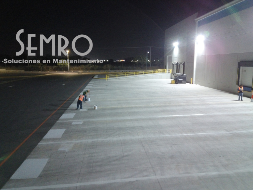 Herramientas industriales alineadas en una mesa de trabajo dentro de un almacén con estanterías naranjas y luces fluorescentes. Herramientas industriales alineadas en una mesa de trabajo dentro de un almacén con estanterías naranjas y luces fluorescentes.