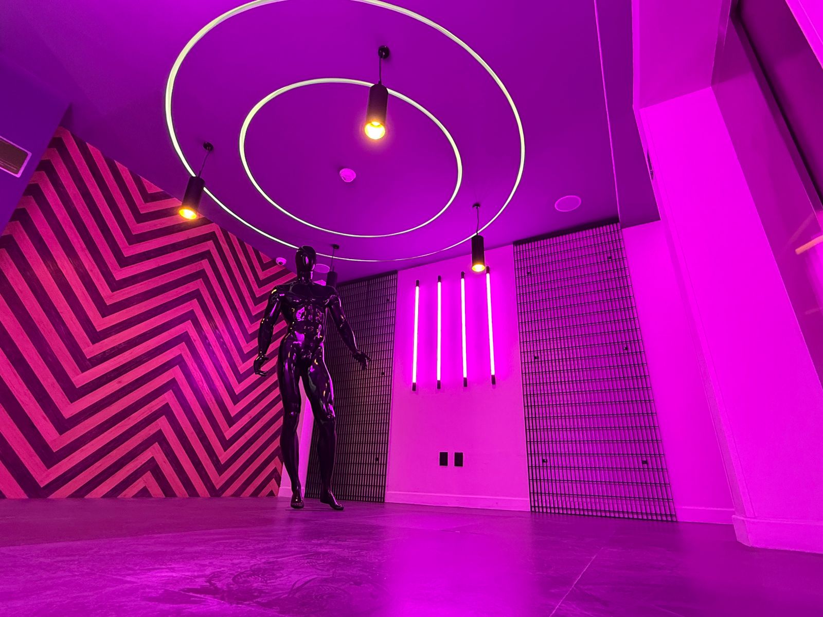 Mujer sonriente en una oficina moderna con plantas y computadoras.