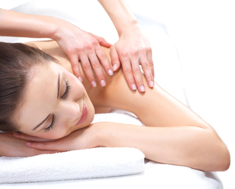 Modern reception area with soft lighting, white counters, wooden accents, cozy seating, and green plants.