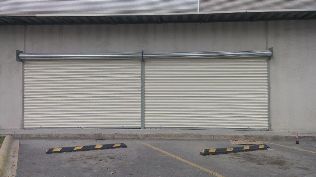 Cortina de acero fabricada en lamina europea pintro crema cal.24 dividida en dos secciones.