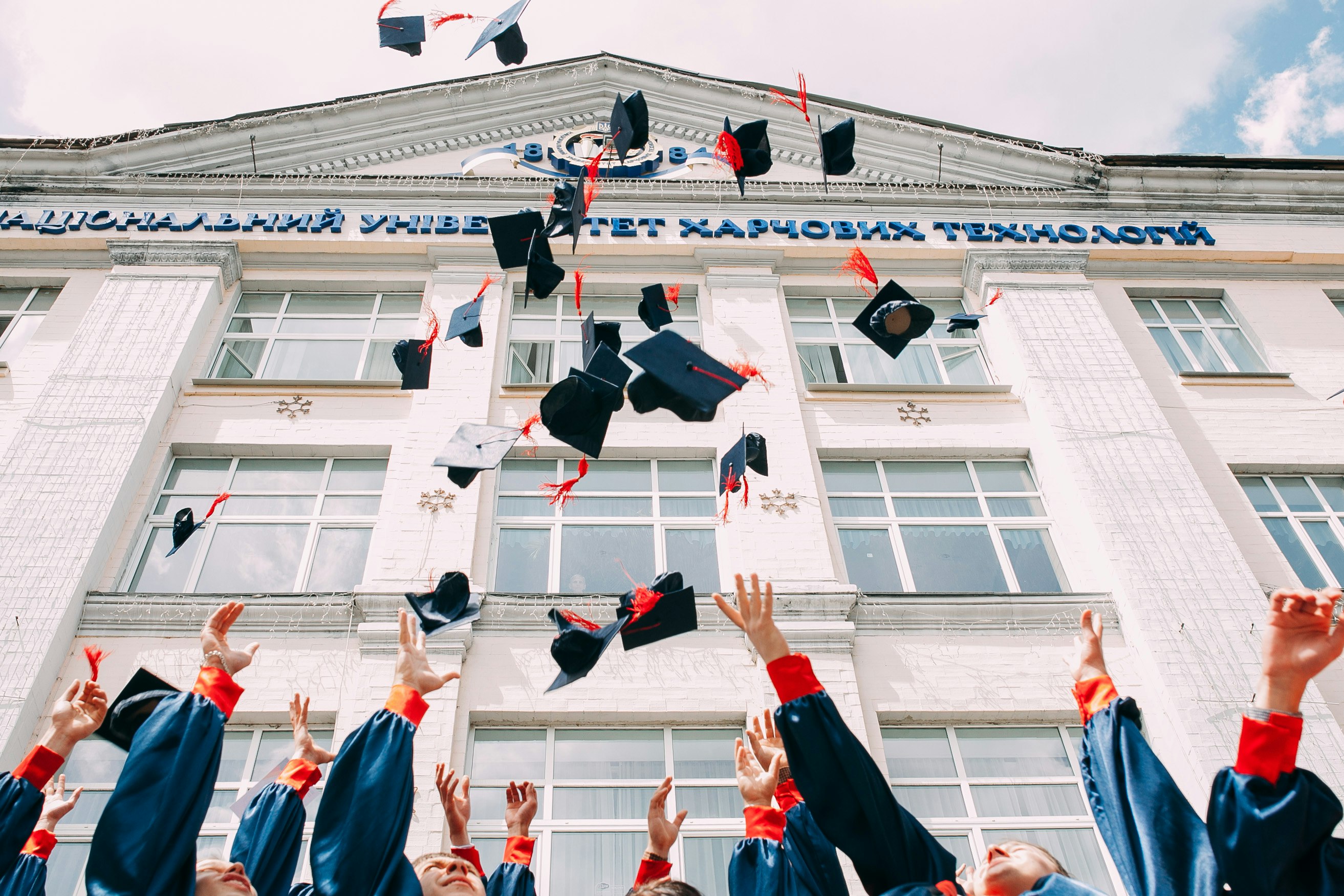 grupo de estudiantes recién graduados lanzando sus birretes al aire