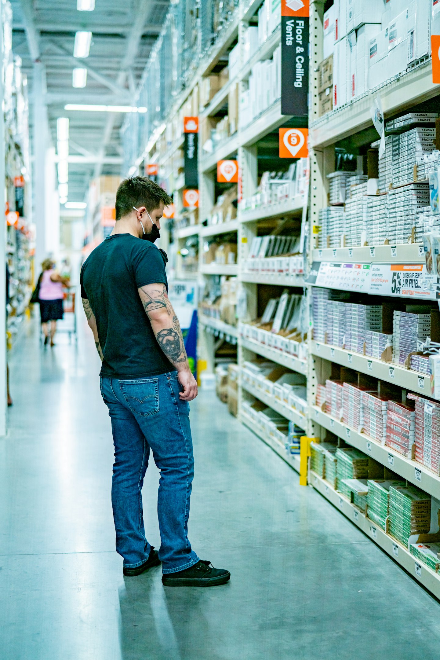 a man standing in a store aisle looking at items