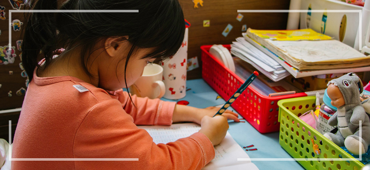 A young girl writing on paper