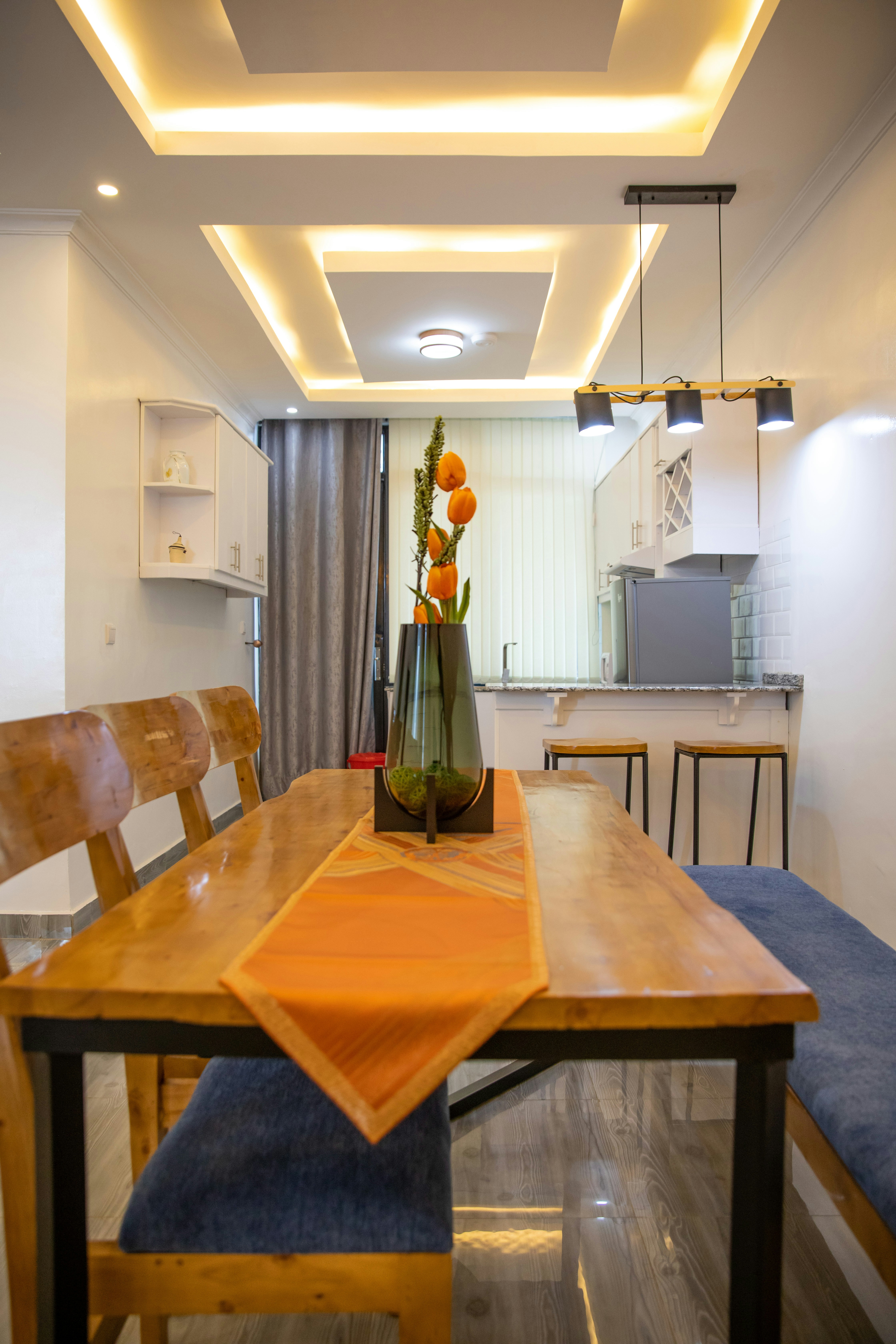 a dining room table with a vase of flowers on it