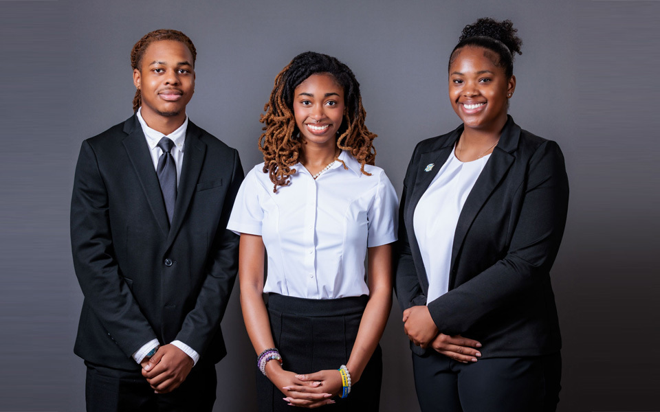 Three people standing together indoors