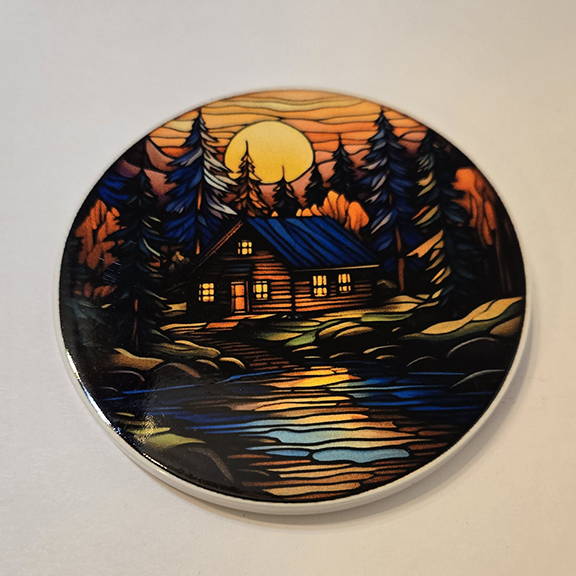 Round ceramic coaster with a stained glass cabin design