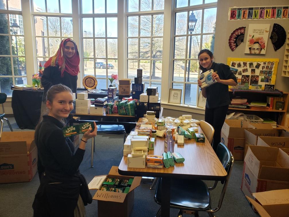 GSK leaders organizing hygiene products for the center after GSK's annual Necessity Drive at Hutchison School.