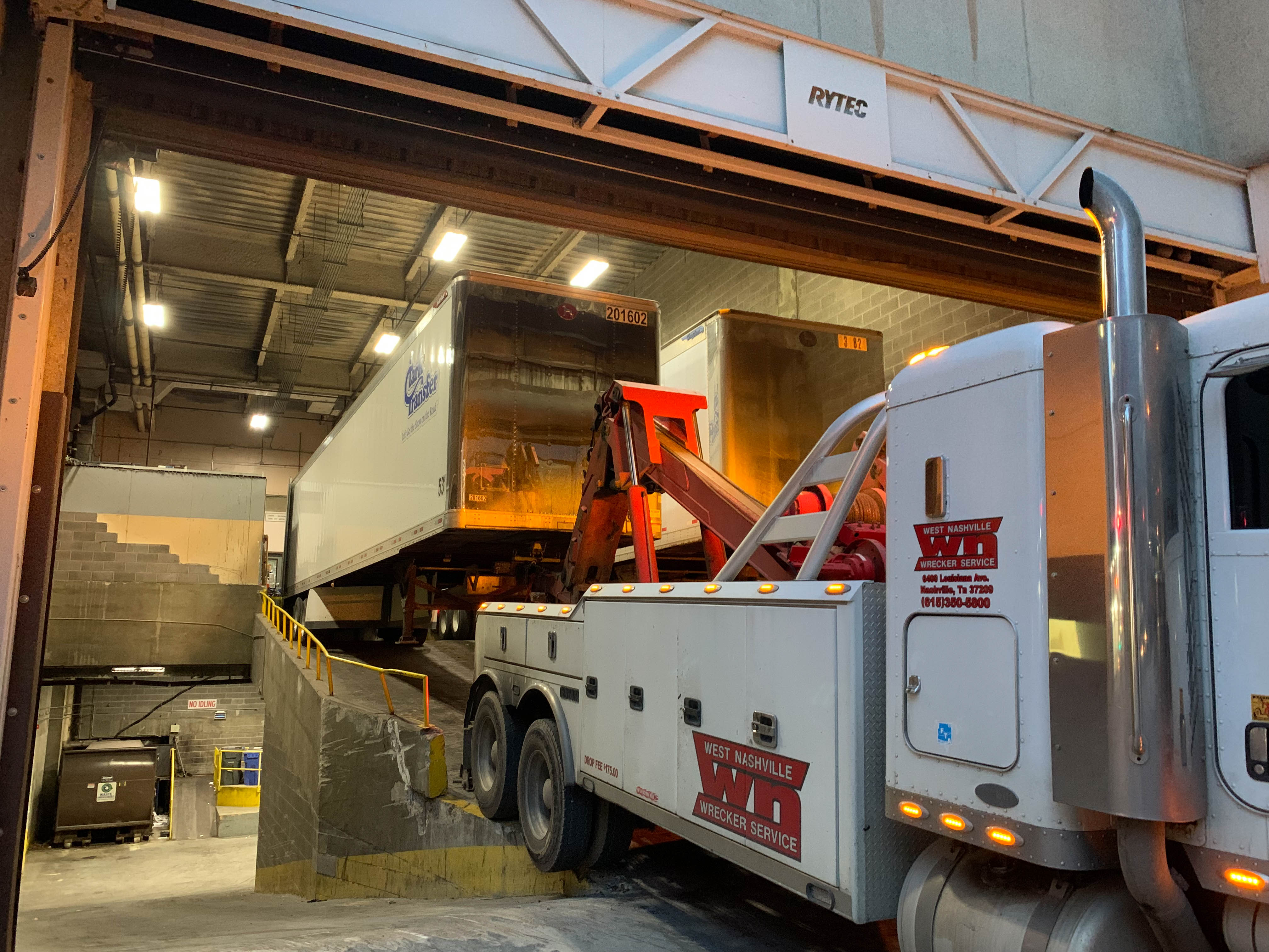 The loading dock ramp was way too steep, so they had to lift the end of the truck to even it out.