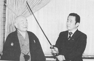 20 July 1997. Nakamura Taizaburo Sensei presenting a sword to Prime Minister Hashimoto Ryutaro.
 PM Hashimoto is a kendo 5th dan. 
The sword was forged by a former Yasukuni Shrine smith.
The sword is a copy of Yamaoka Tesshu's favorite sword, called "Sa-Moji".