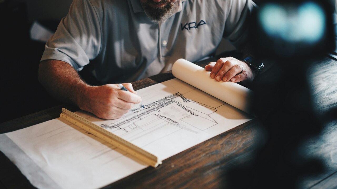 Un arquitecto trabajando en un boceto con un lápiz y una regla