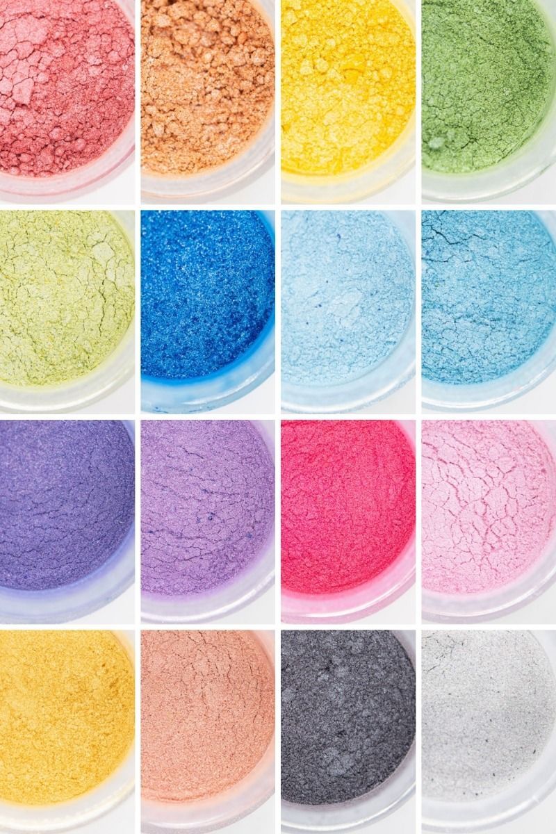 Grid of various colored powdered pigments in containers including red, orange, yellow, green, blue, purple, and pink.