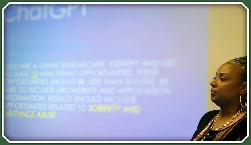 A women giving a lecture from a powerpoint screen