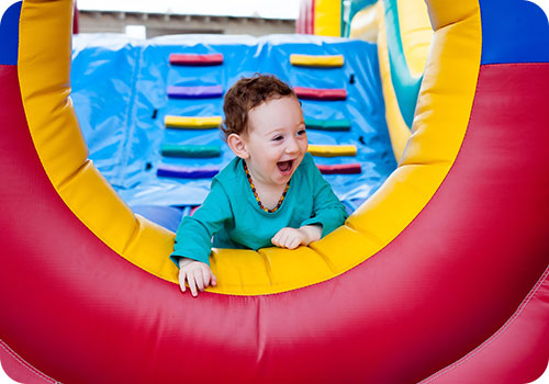 Child on Inflatable Bouncy Castle Slide