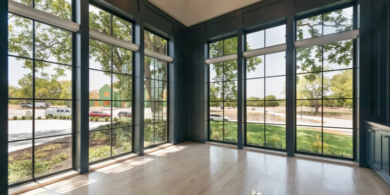 An empty room with several ceiling to floor windows