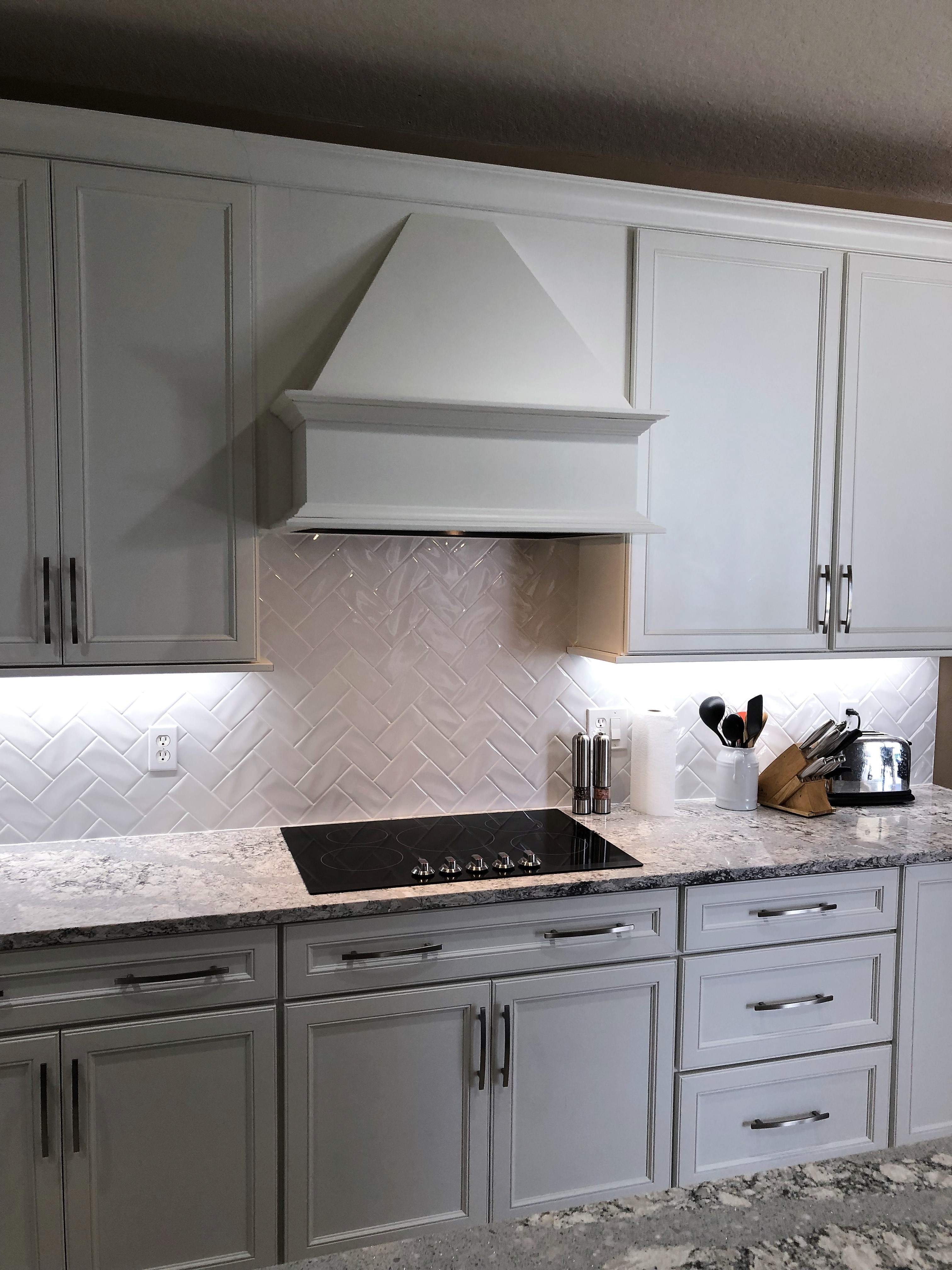 Featuring a classic hand scraped white subway tile set in a chevron pattern.