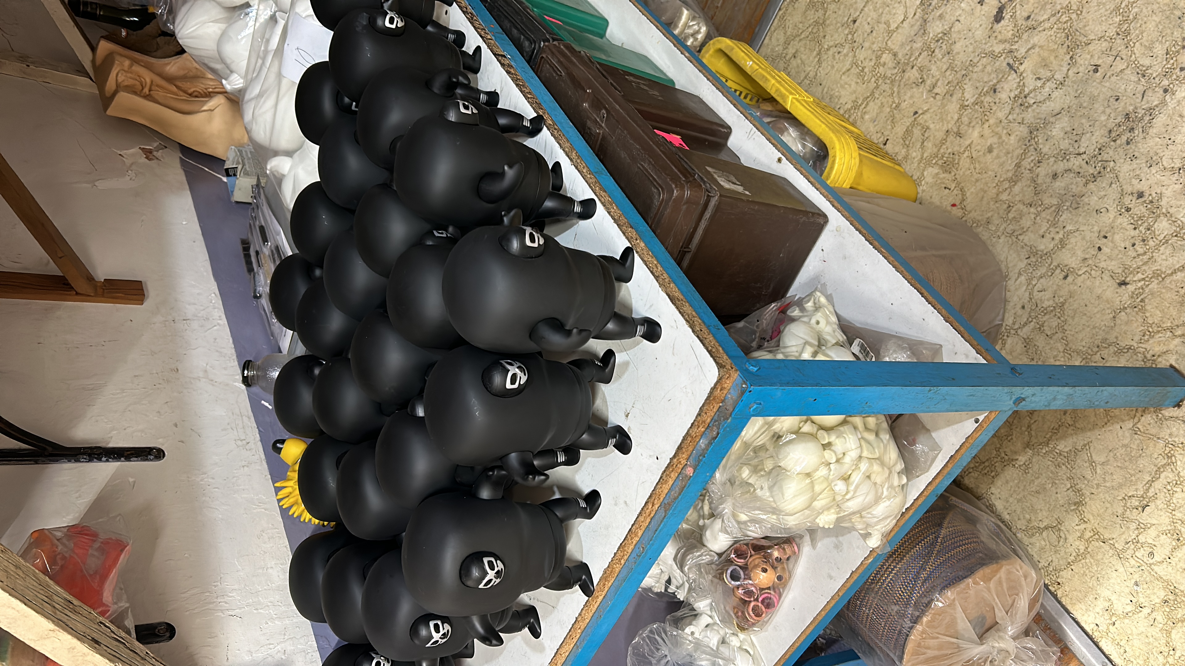 Técnicos en laboratorio fabricando figuras de juguete con moldes metálicos y máquinas de moldeo industrial