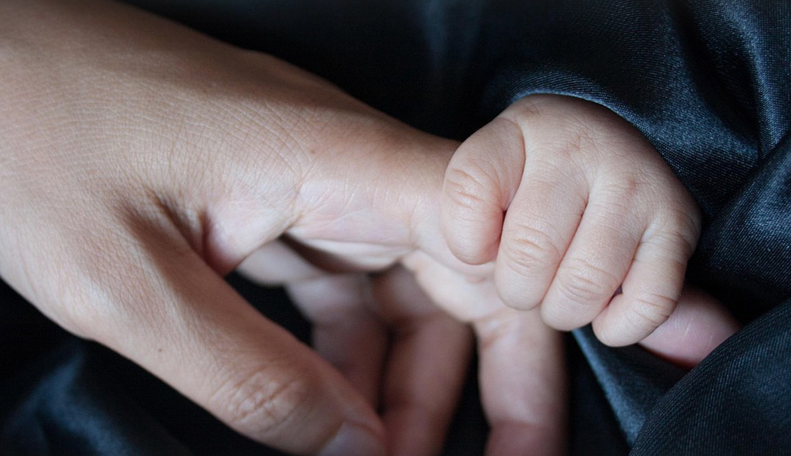 A child’s hand holds a hand. A child’s hand holds a hand.