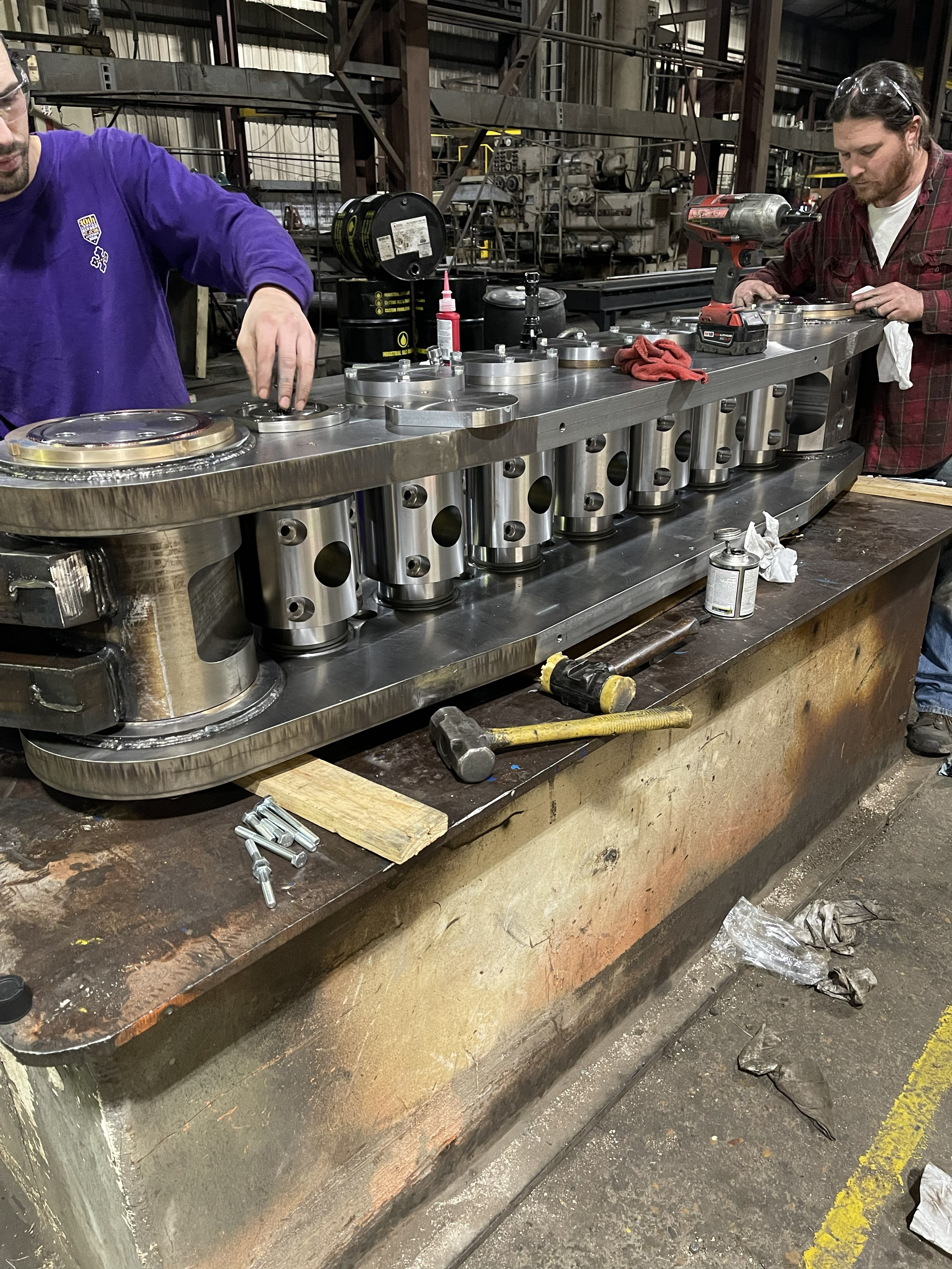 CNC machine performing precision metal drilling in a factory setting with visible sparks.