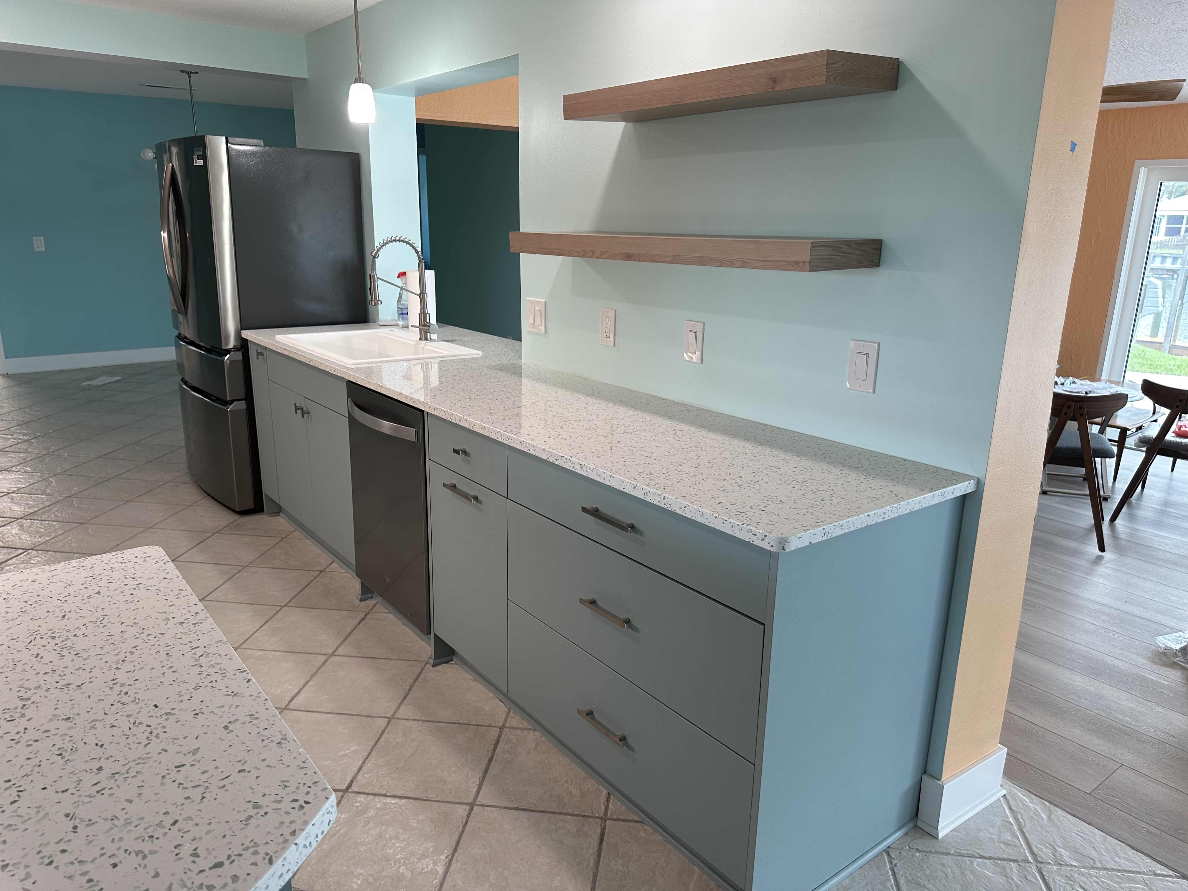 This kitchen features ample counter space along with two free-floating shelves for enhanced accessibility and storage.