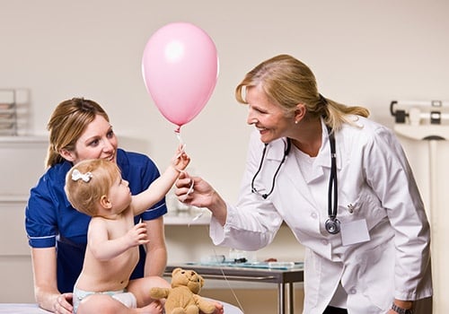 Doctor Handing Baby Girl Balloon