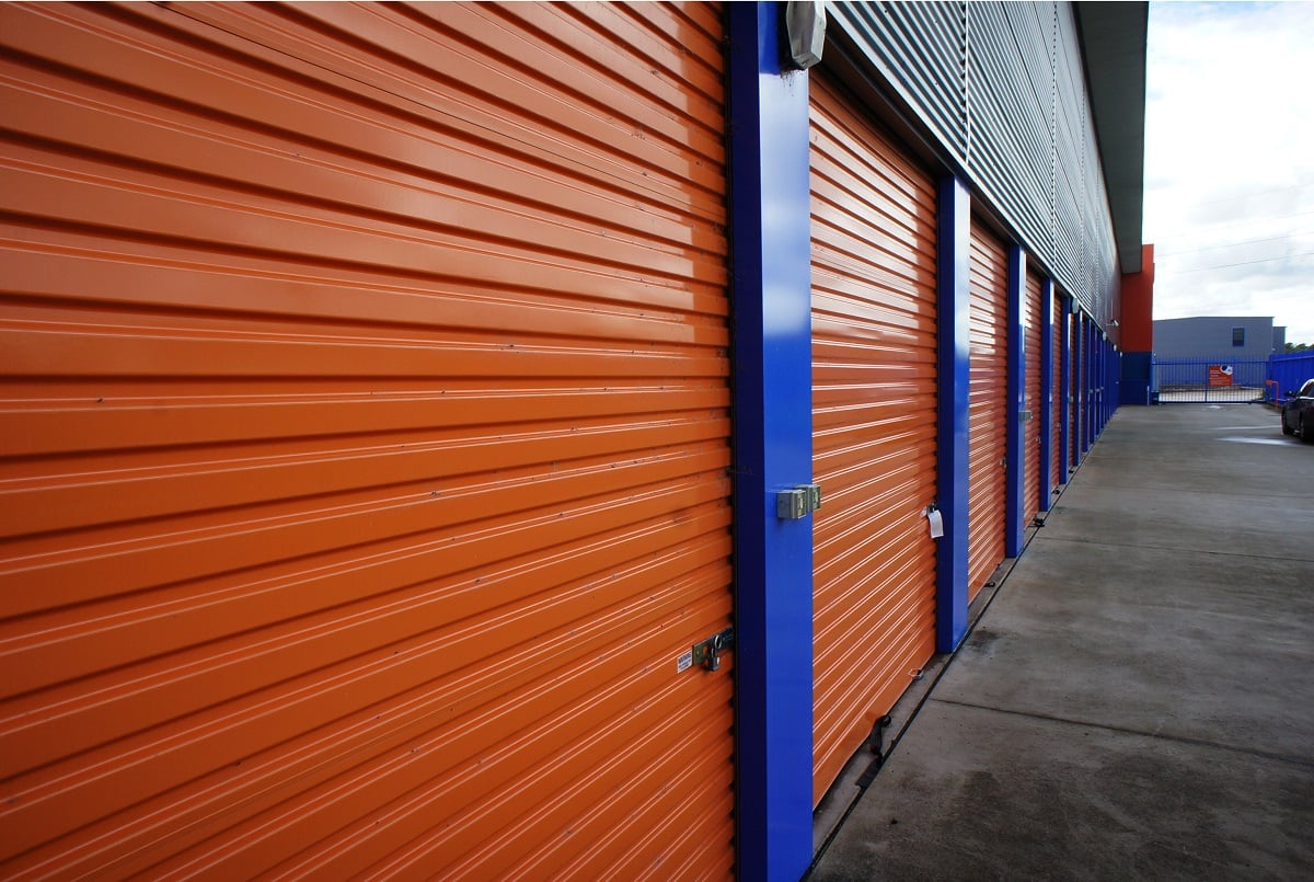 Self-storage units with orange doors and blue trim